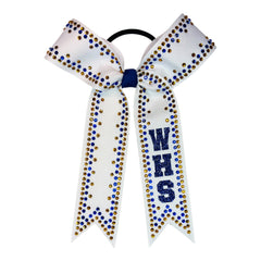 A white cheerleader hair bow with royal blue and gold rhinestone accents, featuring the letters 'WHS' in blue glitter on one ribbon tail, attached to a black elastic band.