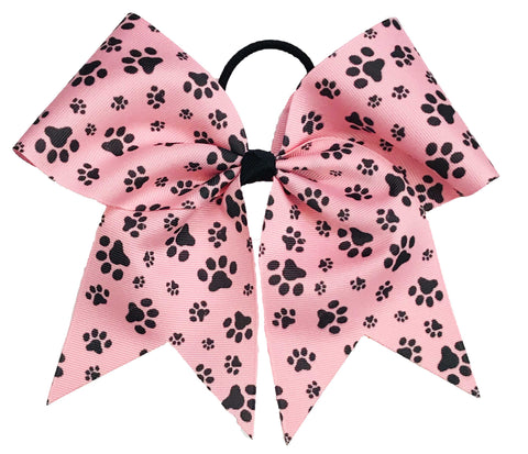 Pink hair bow with black paw prints on a white background