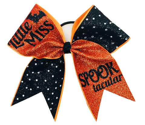 Halloween-themed glittery bow with rhinestones and "Little Miss Spooktacular" text on an orange and black background