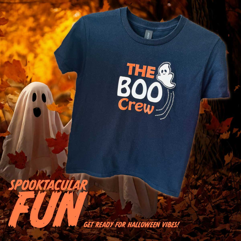 Black t-shirt with 'The Boo Crew' design on a Halloween-themed background with ghosts and leaves.