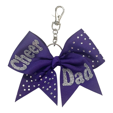 Purple bow keychain with 'Cheer Dad' text and rhinestones on a white background