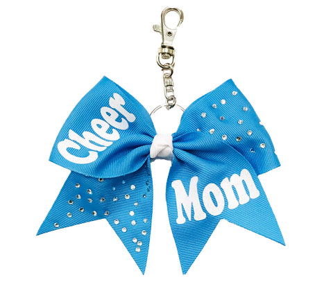 Columbia Blue cheer mom bow keychain with sparkling rhinestone accents, white glitter “Cheer Mom” lettering, and a silver clasp attachment—perfect for bags, keys, or gifts.