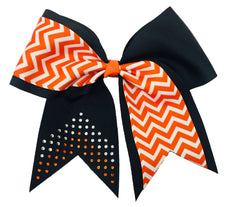 Cheerleading bow with orange and white chevron pattern and black accents and rhinestones on a white background