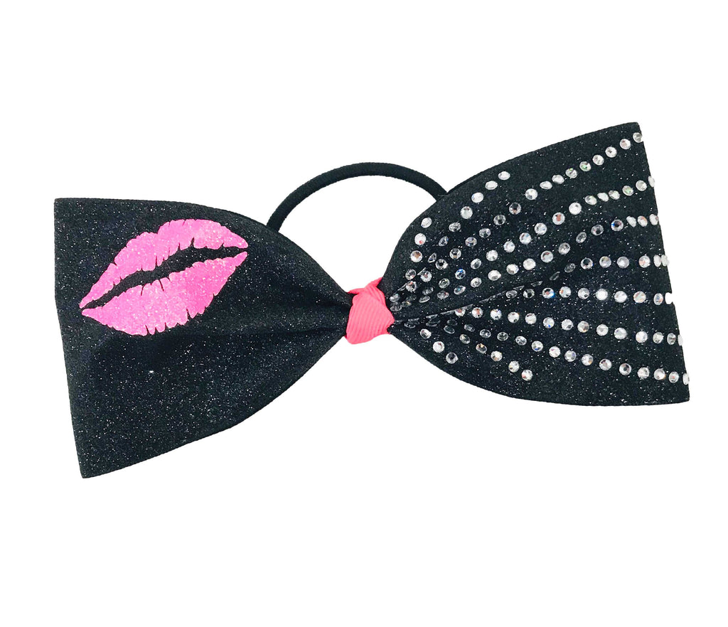 Black tailless cheer bow with neon pink kiss lips and rhinestone details on a white background