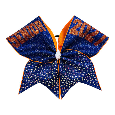 A cheerleader hair bow featuring a royal blue glitter top section with orange glitter text reading 'SENIOR' and '2027', and a lower section covered in small clear AB rhinestones, finished with orange trim.