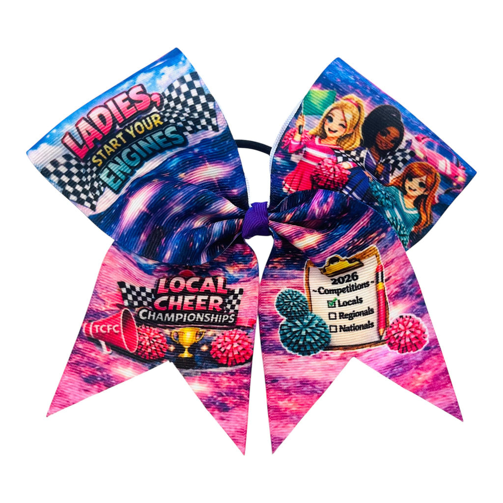 A large cheerleader hair bow with a colorful racing-themed print, featuring text like 'LADIES, START YOUR ENGINES,' 'LOCAL CHEER CHAMPIONSHIPS,' and '2026 Competitions Locals Regions Nations,' along with cartoon characters and pink pom-pom graphics, attached to a black elastic band.